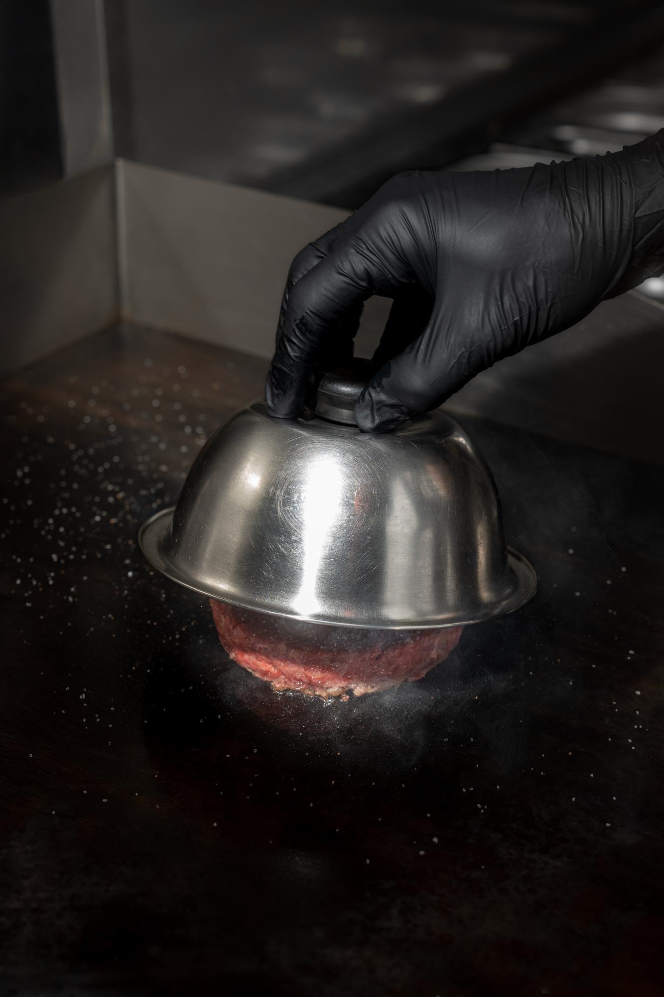 Chef preparing plated dish on stainless table